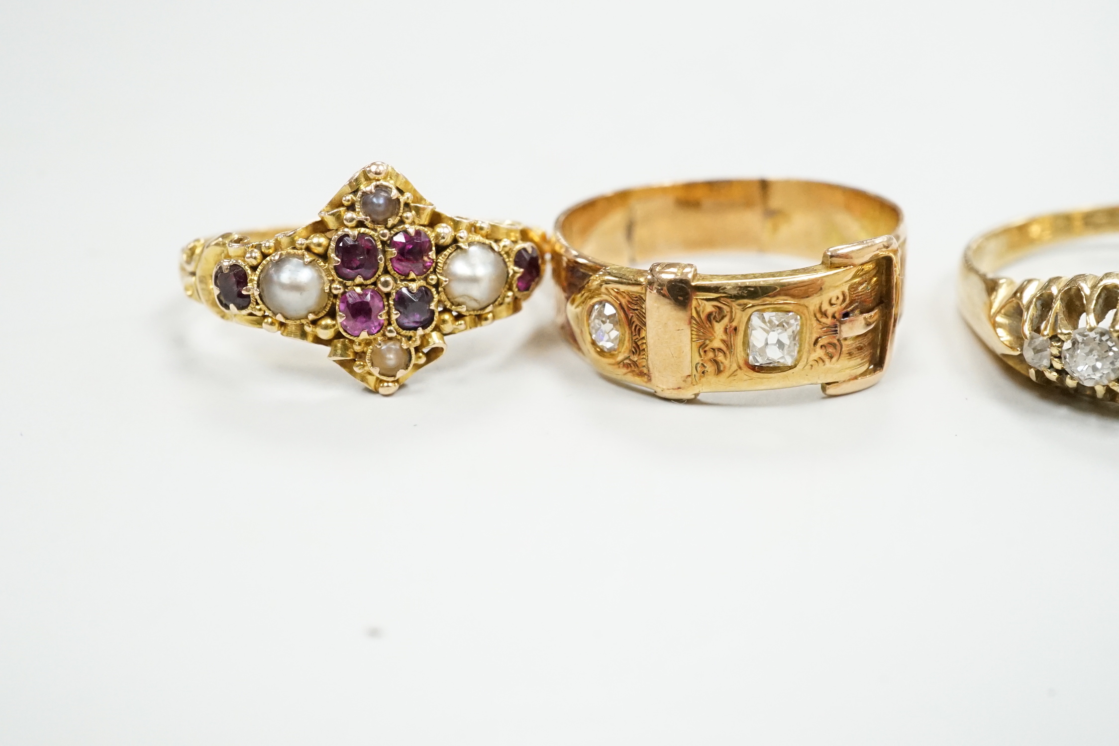 A Victorian 18ct gold and gem set dress ring, size I, three other 18ct and gem set rings and a yellow metal and diamond set buckle ring, gross weight 13.3 grams.